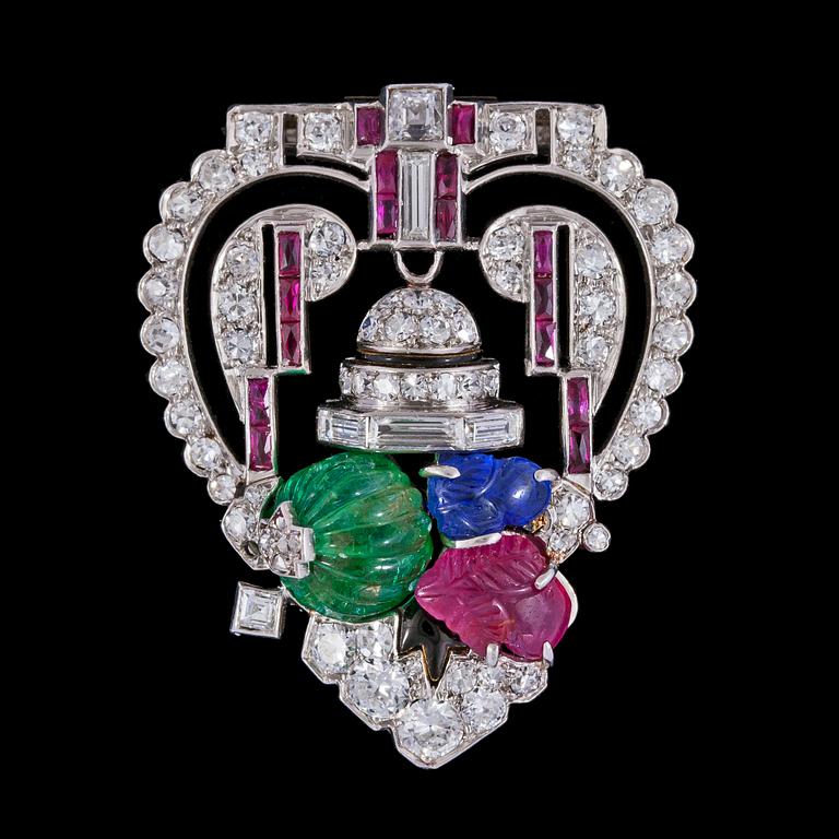 BROSCH/CLIP, skuren smaragd, rubin och safir med baguette- och åttkantslipade diamanter. Art Deco, ca 1925.