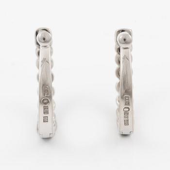 A pair of earrings in 18K white gold set with round brilliant-cut diamonds.