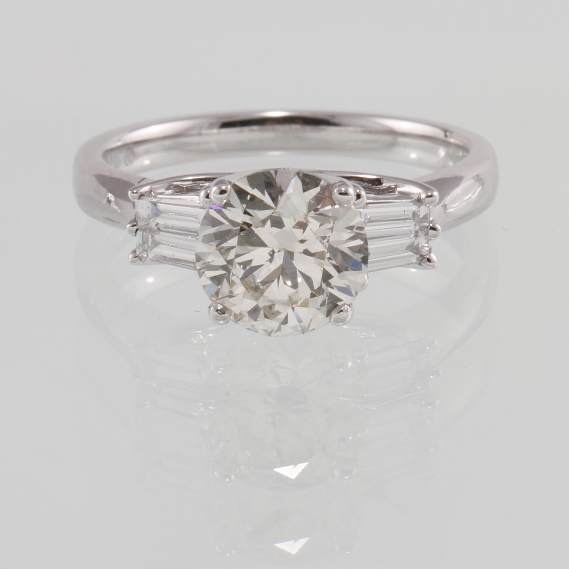 RING, 18K vitguld med briljantslipad diamant 2.00 ct samt 4 baguettslipade diamanter 0.31 ct. Vikt 4,5 gram.