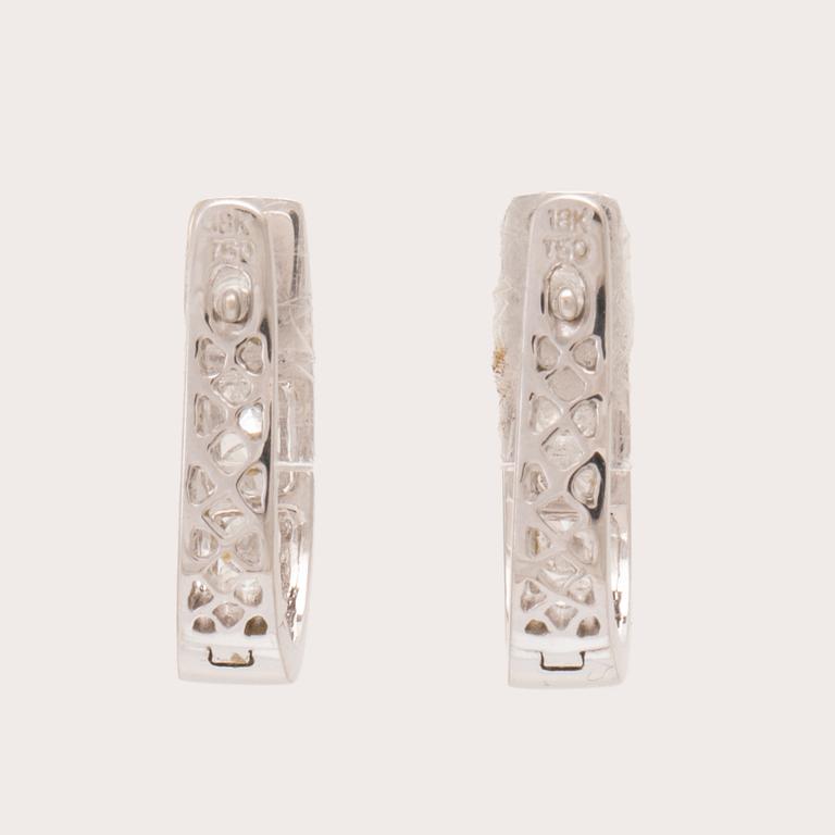 A pair of 18K white gold earrings set with round brilliant-cut diamonds.