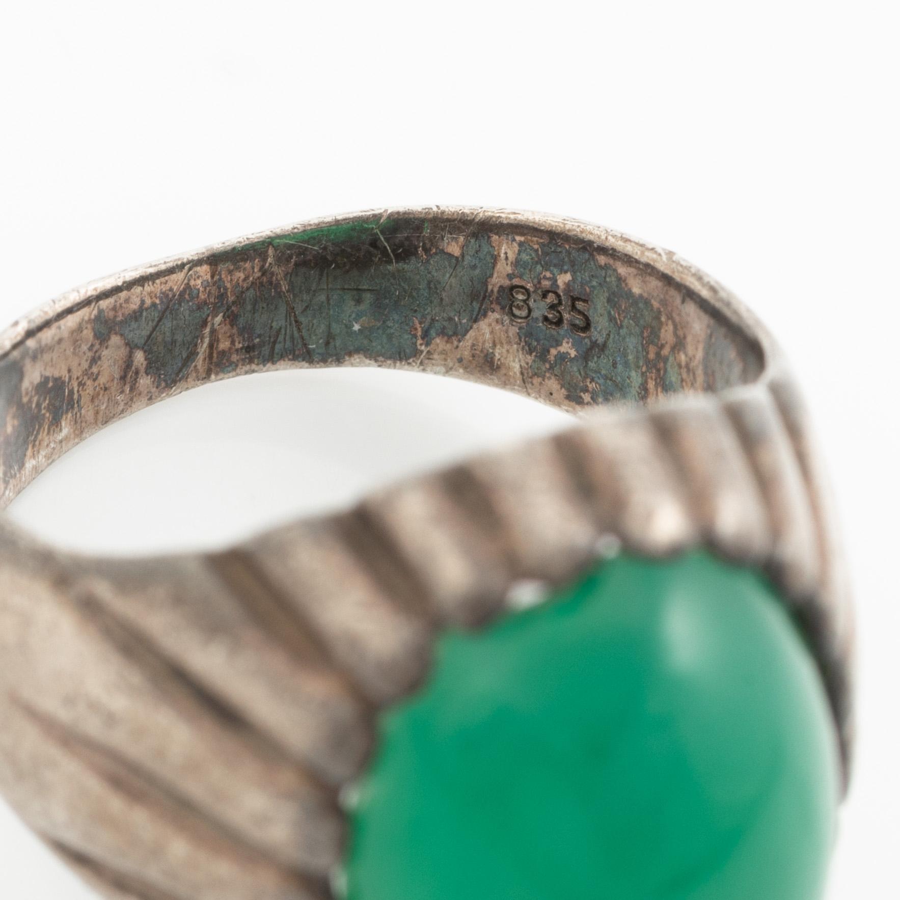 Silver ring with a green cabochon-cut stone.