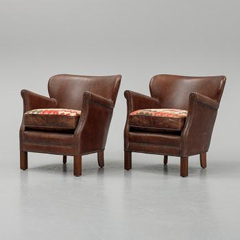 A pair of Artwood leather easy chairs.