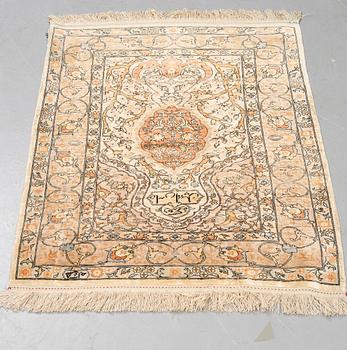 A rug, old silk Hereke, signed, ca 84,5 x 66 cm.