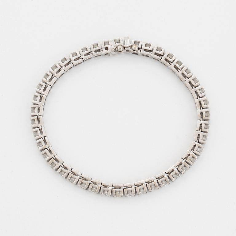 A tennis bracelet in 18K gold set with round brilliant-cut diamonds.