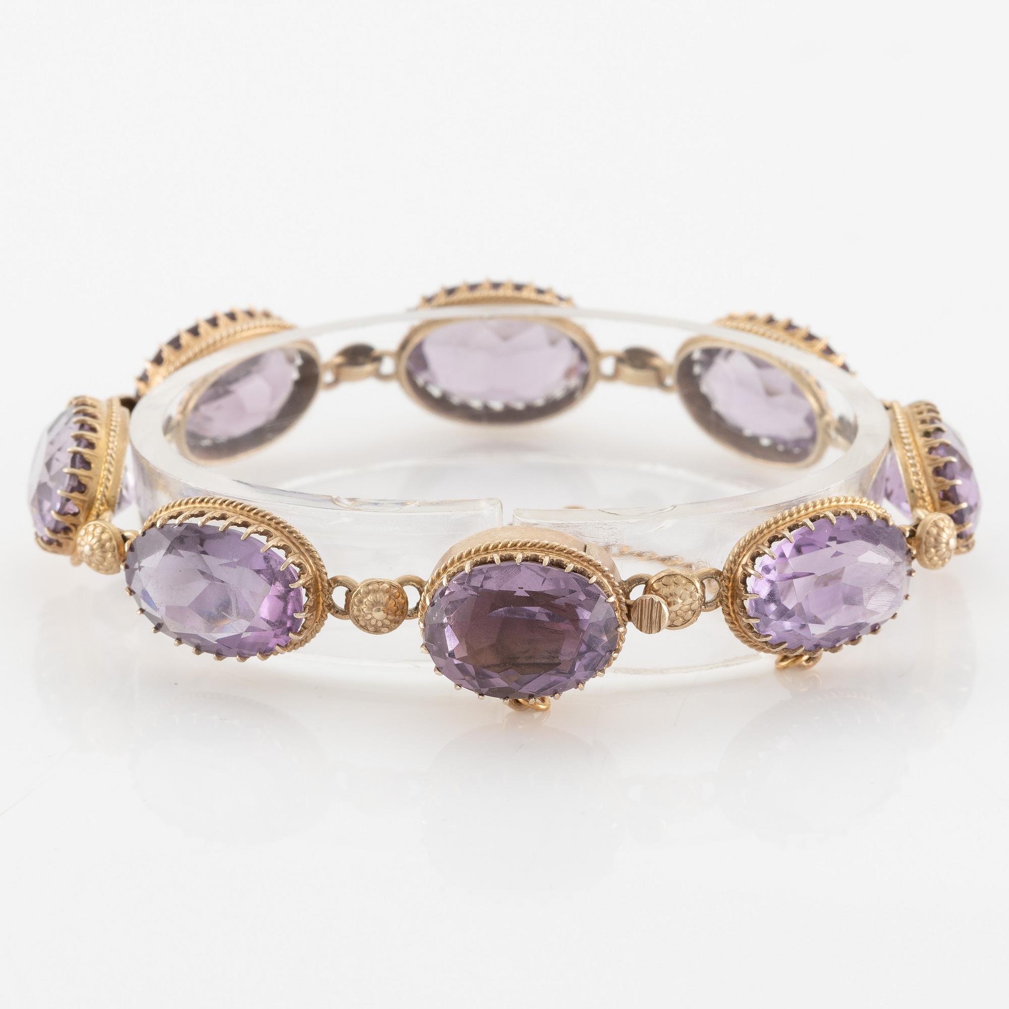 A set with a necklace, a bracelet, a brooch, and a ring.