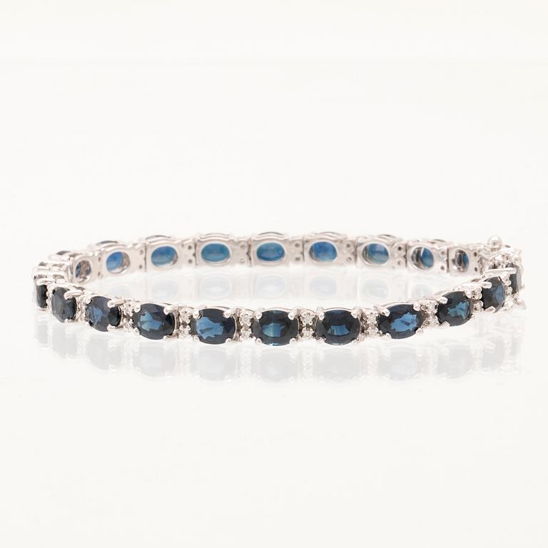 An 18K white gold bracelet set with oval faceted sapphires and round brilliant-cut diamonds.