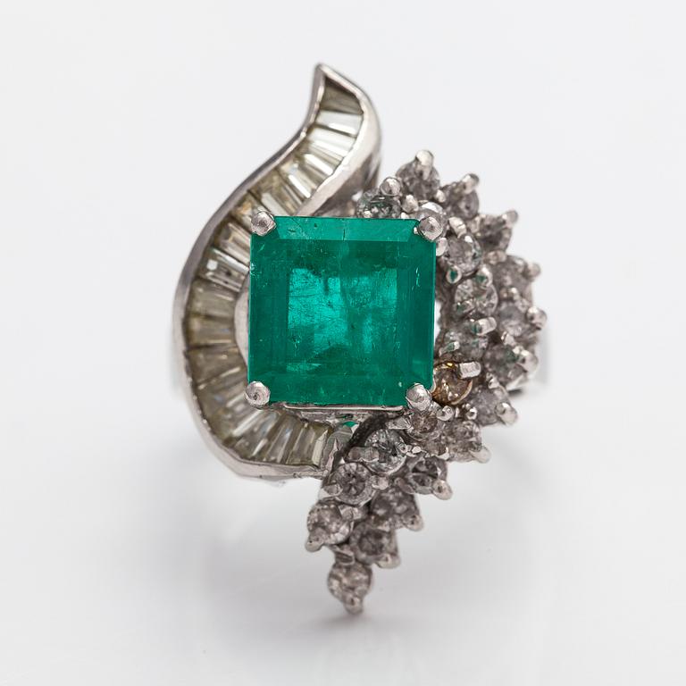 A platinum ring with a ca. 3.20 ct emerald and diamonds ca. 1.16 ct in total.