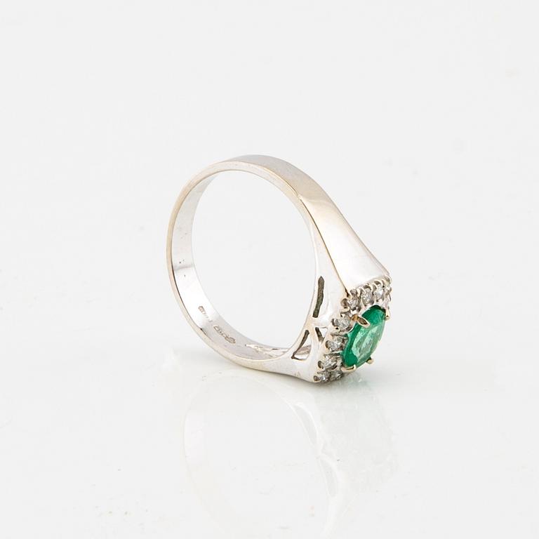 Ring in 18K white gold with an oval faceted emerald and round brilliant-cut diamonds.