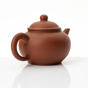 A six part red yixing Gongfu set; teapot, four cups and a tray, China, 1980s.