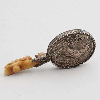 A silver gilt copper mirror with nefrite handle in the shape of a belt hook.