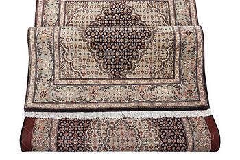 A Tabris rug, part silk, c. 198 x 81 cm.