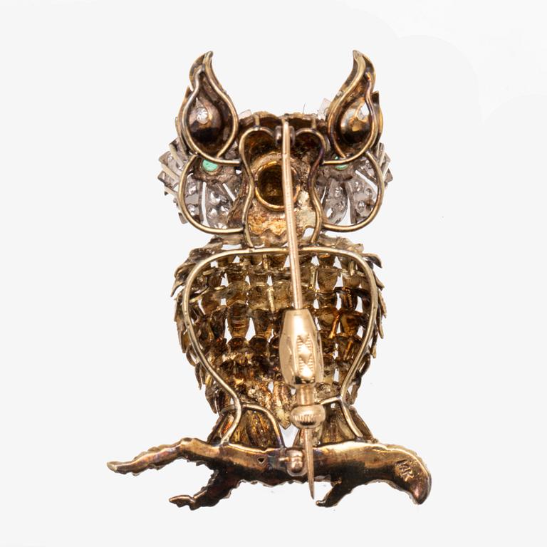 An 14K white and red gold brooch set with single cut diamonds and possibly emeralds.