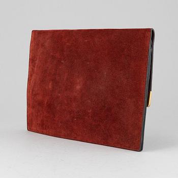 Cartier, a red suede clutch.