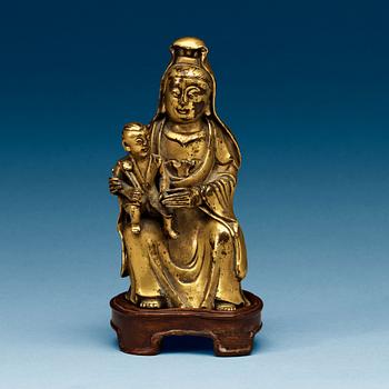 A seated gilt bronze figure of Guanyin with a small boy, Qing dynasty, 18th Century.