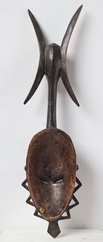 A sculptue and two masks reportedly from The Ivory coast, from the second half of the 20:th century.