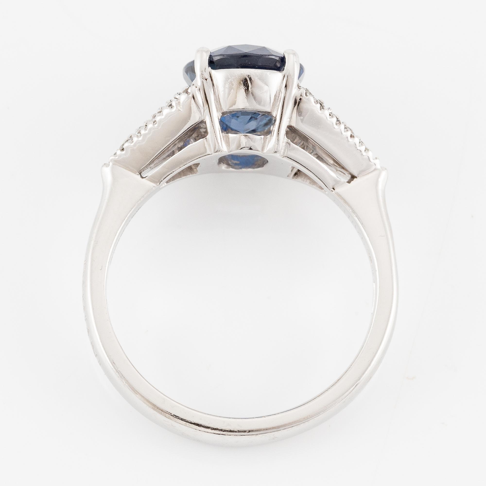 Damiani ring platina med en fasettslipad safir samt triangulära- och runda briljantslipade diamanter.