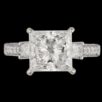 A princess cut diamond ring, 4.03 cts. and smaller brilliant cut diamonds.