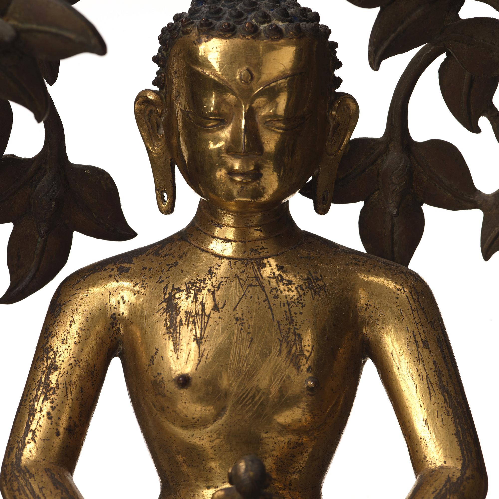 A large Nepalese gilt bronze buddha on a throne with mandorla, 18/19th Century.