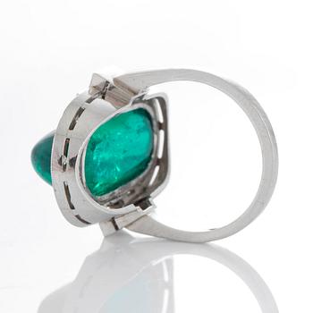 A platinum ring set with a cabochon-cut emerald ca 7 cts and brilliant and baguette-cut diamonds.