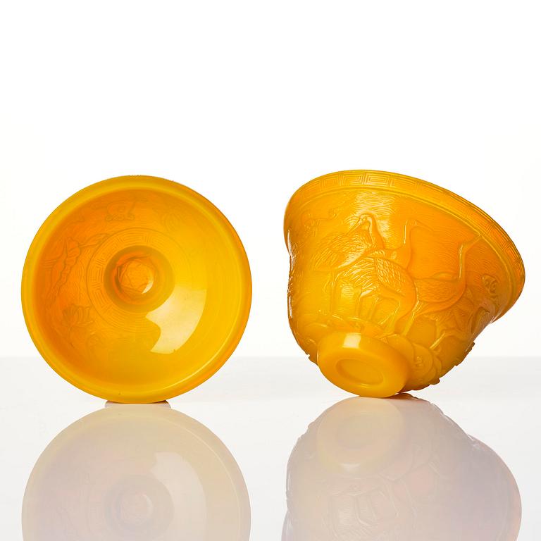 A well carved yellow glass 'crane and lotus' cup with cover, presumably late Qing dynasty.