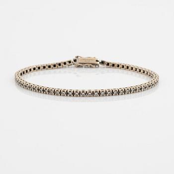 An 18K gold tennis bracelet set with round brilliant-cut diamonds.