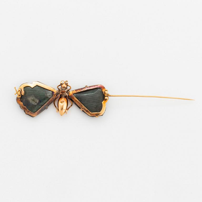 A butterfly brooch in 14K gold set with labradorite, rubies, rose-cut diamonds and garnets.