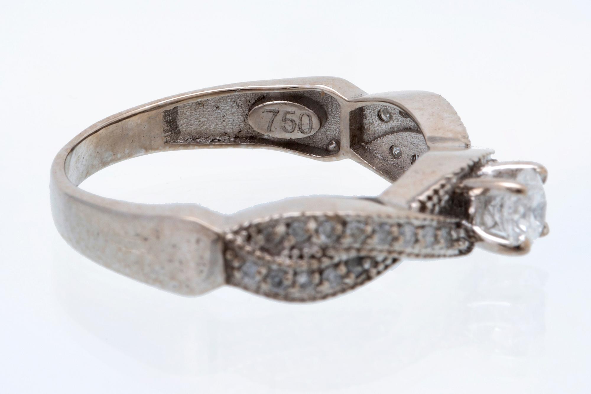 Ring 18K vitguld med 1 briljant ca 0,30 ct och briljanter ca 0,15 ct totalt.