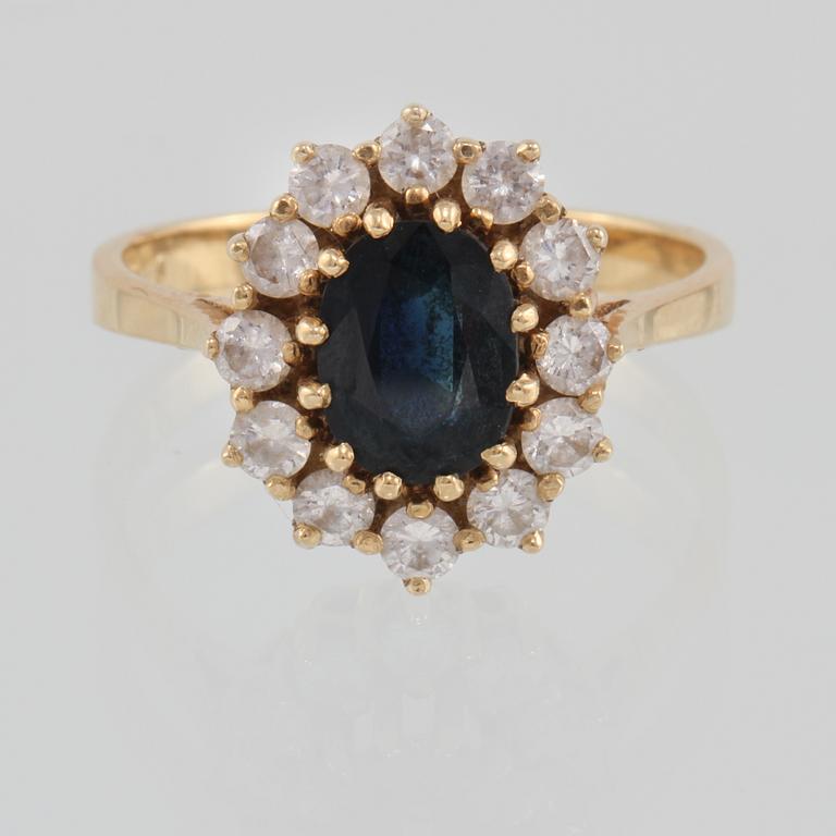 RING, 18K guld med ovalslipad blå safir samt 12 briljantslipade diamanter 0.73 ct, kattfotstämplad. Vikt 5,3 gram.