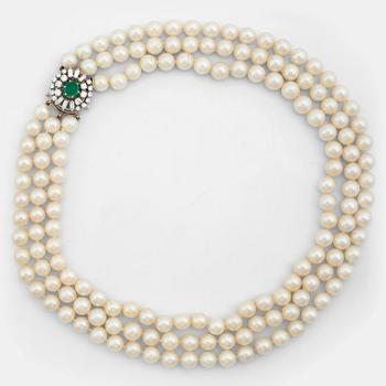 791. A three strand cultured pearl necklace, clasp with cabochon cut emerald circa 1.68 cts and diamonds.