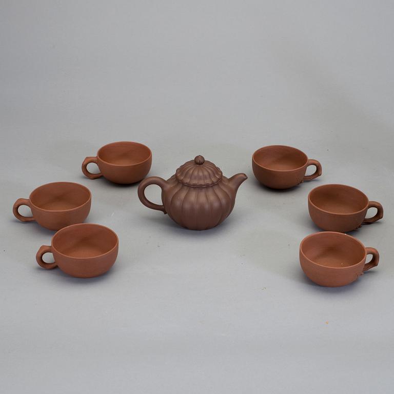 A set of six Chinese earthware cups and a pot, 20th Cent.