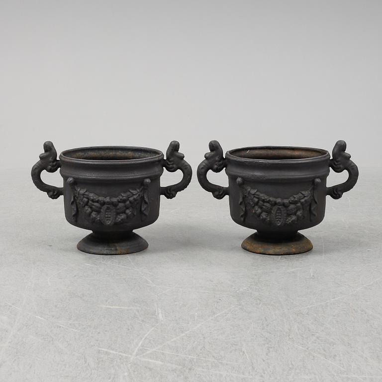 A 20th Century pair of cast iron flower pots.