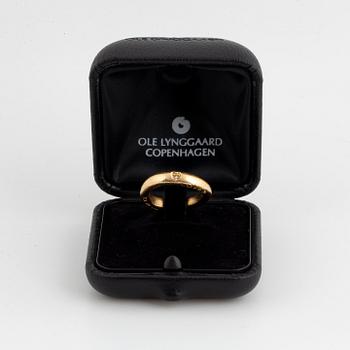 An 18K gold Ole Lynggaard ring set with a round brilliant-cut diamond.