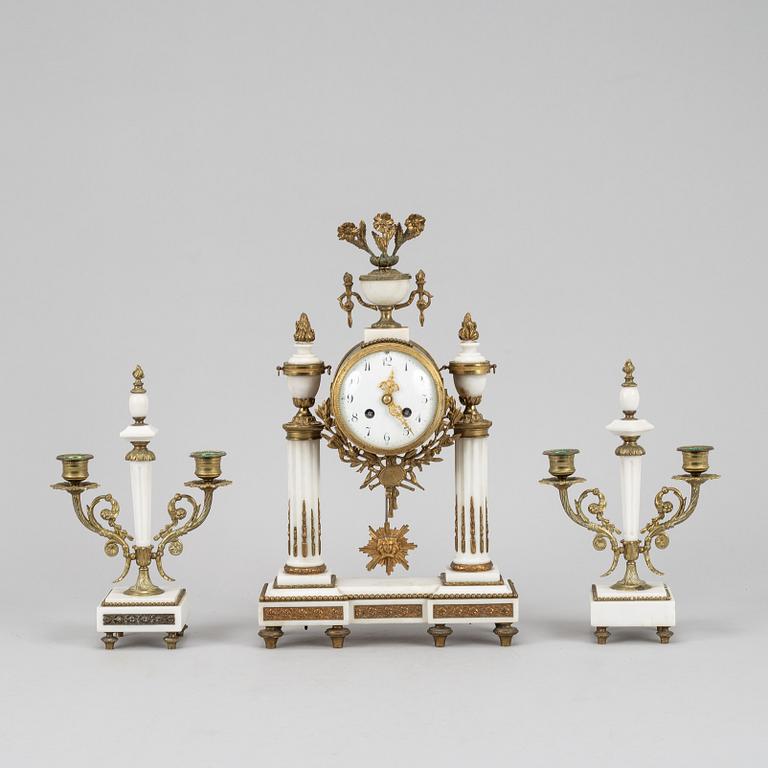 A Louis XVI style pendulum clock and a pair of candelabra, early 20th century.