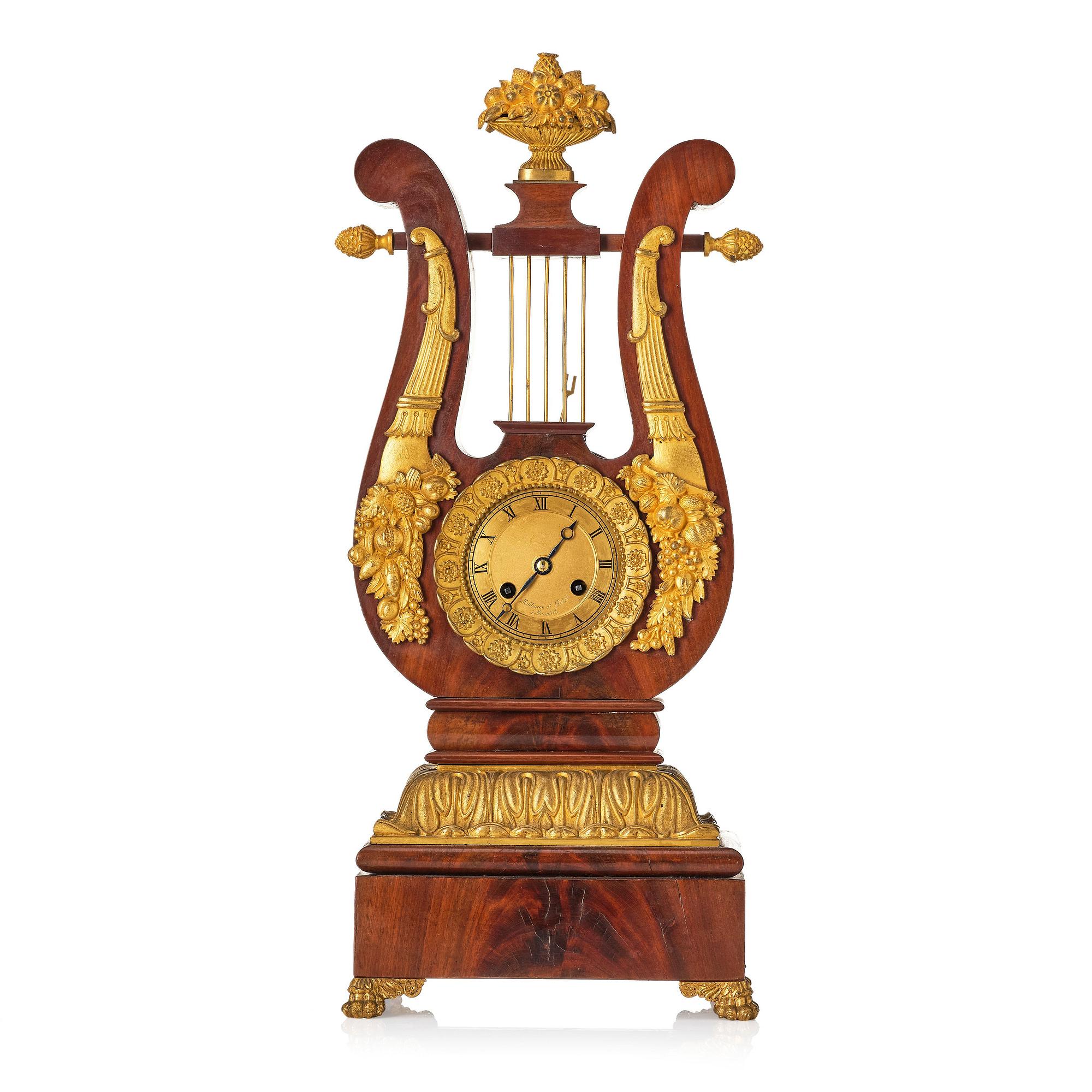 A French Empire mahogany, ormolu and gilt metal lyre-shaped mantel clock, early 19th century.