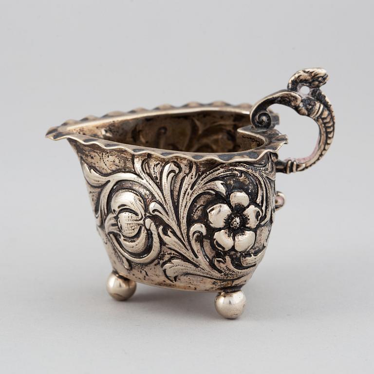 A small silver Baroque style  heart-shaped jug on ball feet.