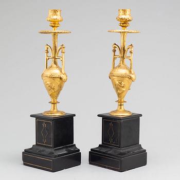 A late 19th century table clock and a pair of candlesticks.
