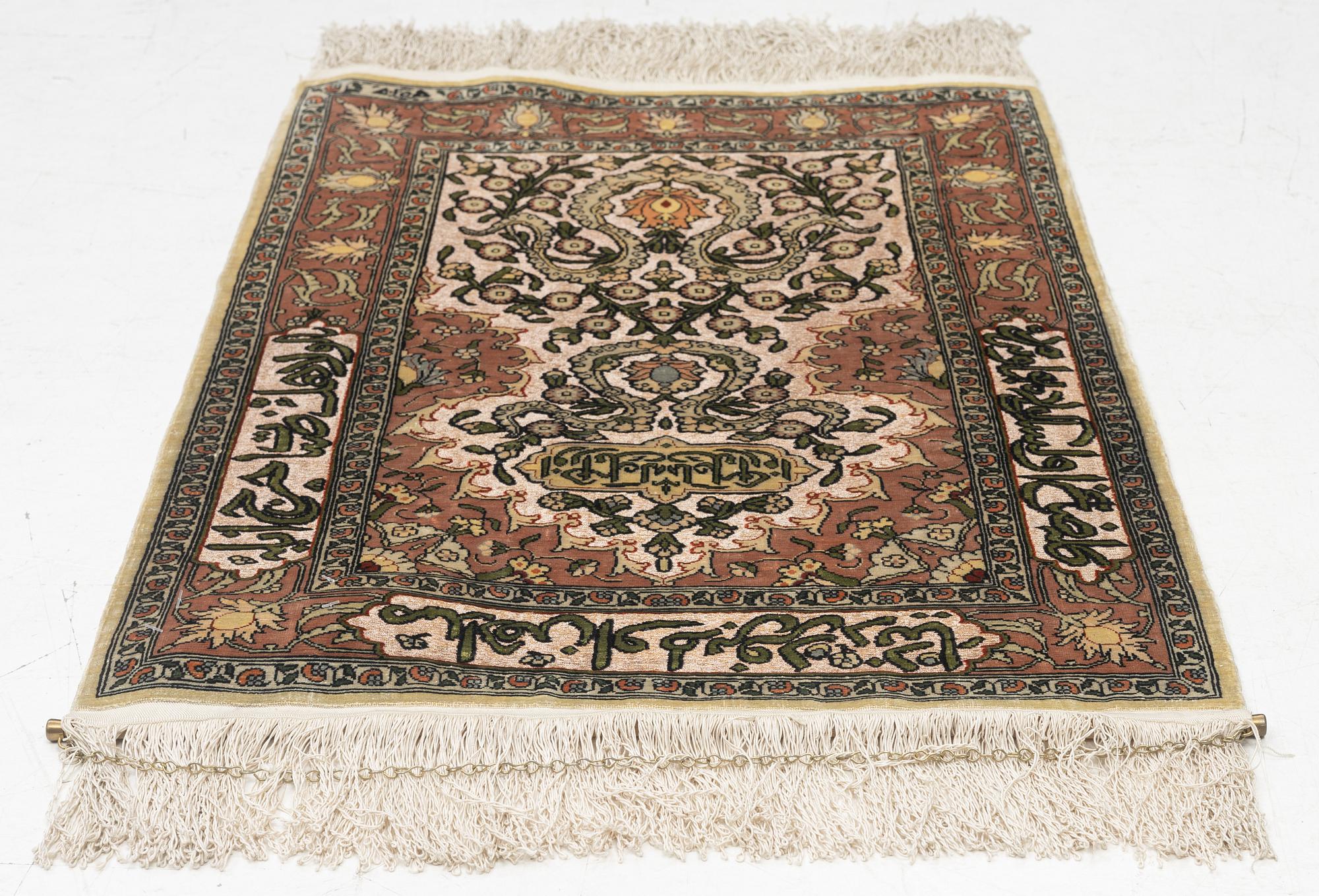 A silk Hereke rug, c. 77 x 53 cm.