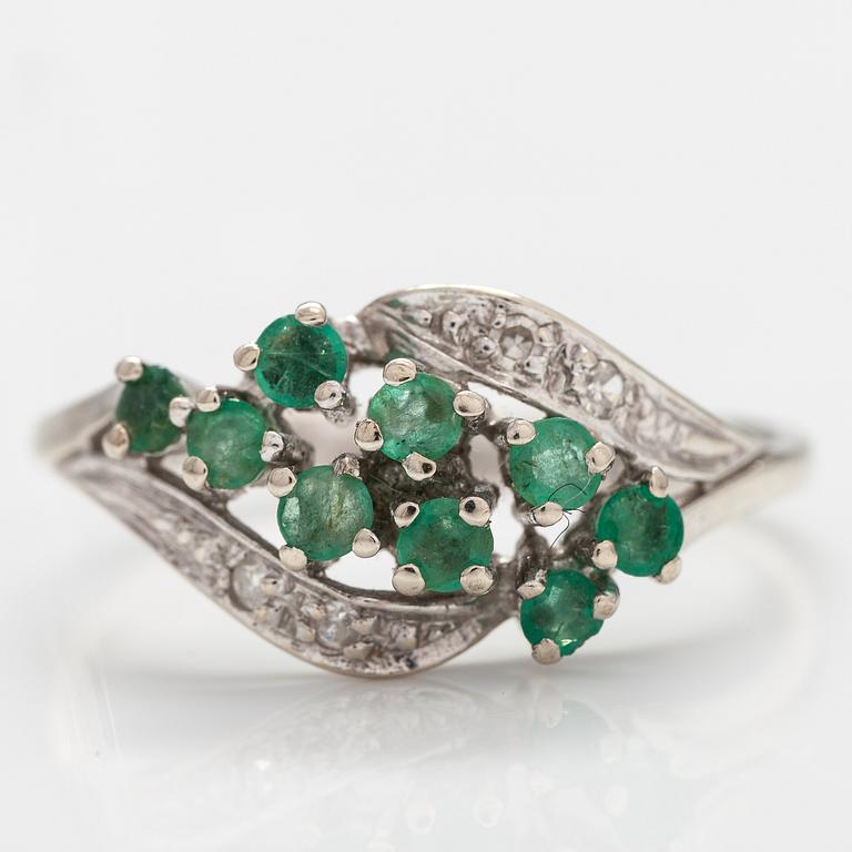 A 14K white gold ring with emeralds and diamonds ca. 0.02 ct in total. Import marked Turun Hopea, Turku 1995.