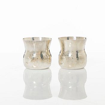 A pair of beakers, two napkin rings, and 17 pieces of cutlery, silver.