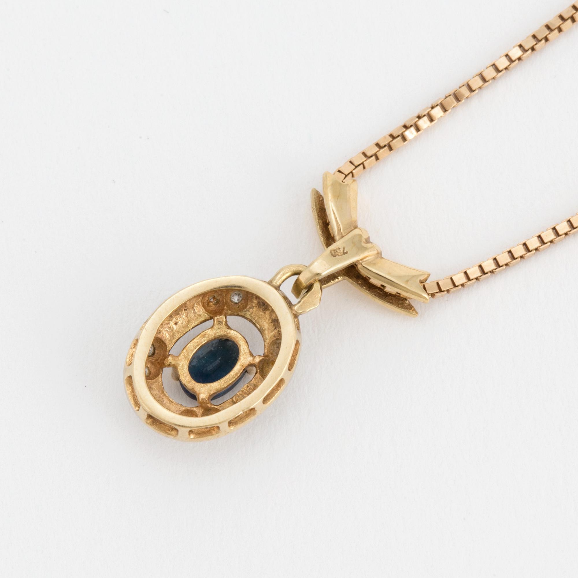 An 18K gold chain and pendant set with an oval, mixed-cut, synthetic sapphire surrounded by eight-cut diamonds.