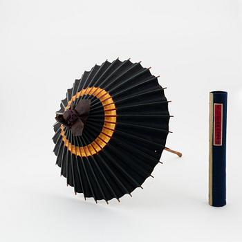 A set of six fans and two umbrellas and a wig/pony tail. Japan, early 20th Century.