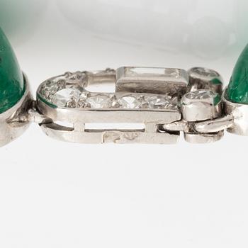 An art deco platinum necklace/bracelet combination with cabochon-cut emeralds.