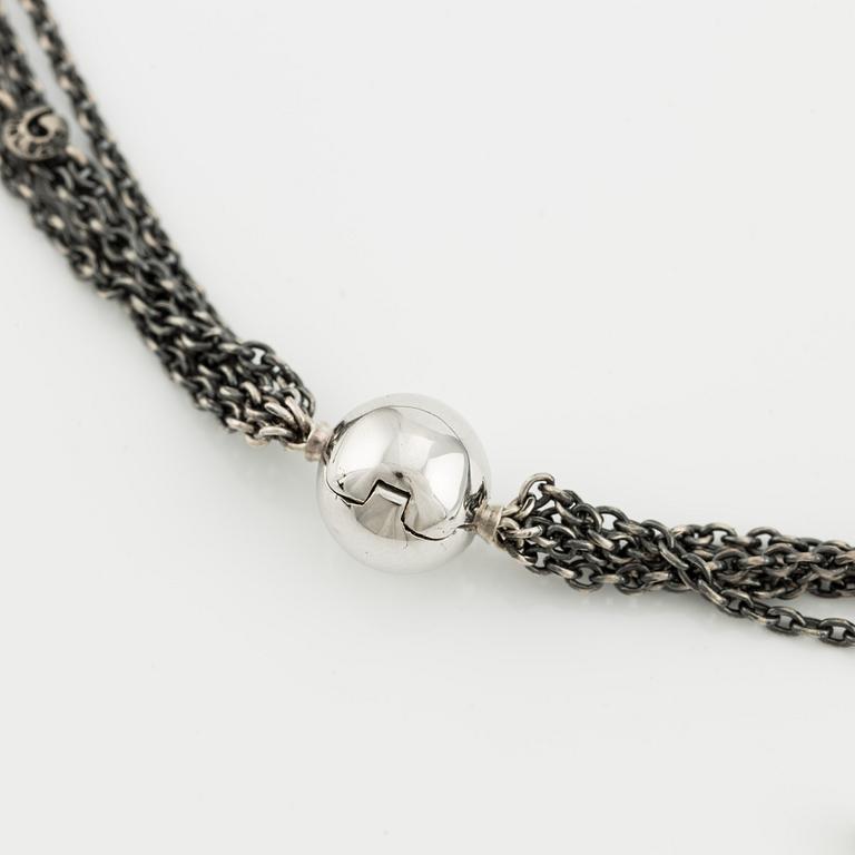 A clasp in 18K white gold with two Ole Lynggaard silver necklaces.