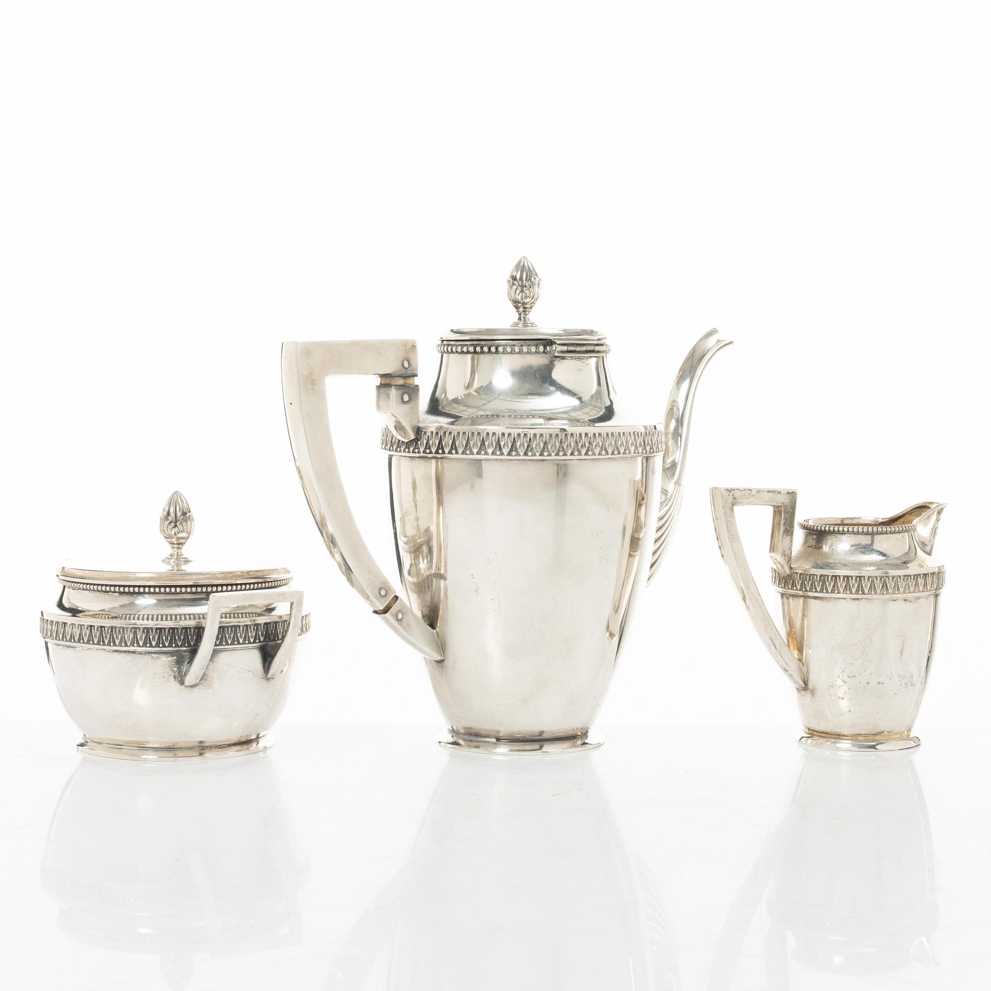 A silver coffee pot, creamer and sugar bowl, import marks of Axel Larson, Helsingborg 1920.
