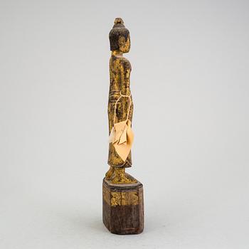 A Burmese sculpture of a standing buddha, circa 1900.