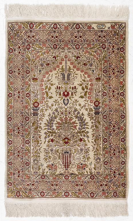 A silk Hereke rug, signed, c. 93 x 64 cm.