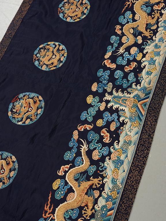 AN ALTAR DRAPE, embroidered silk. A fragment. China late Qing dynasty. 66,5 x 213-231,5 cm.