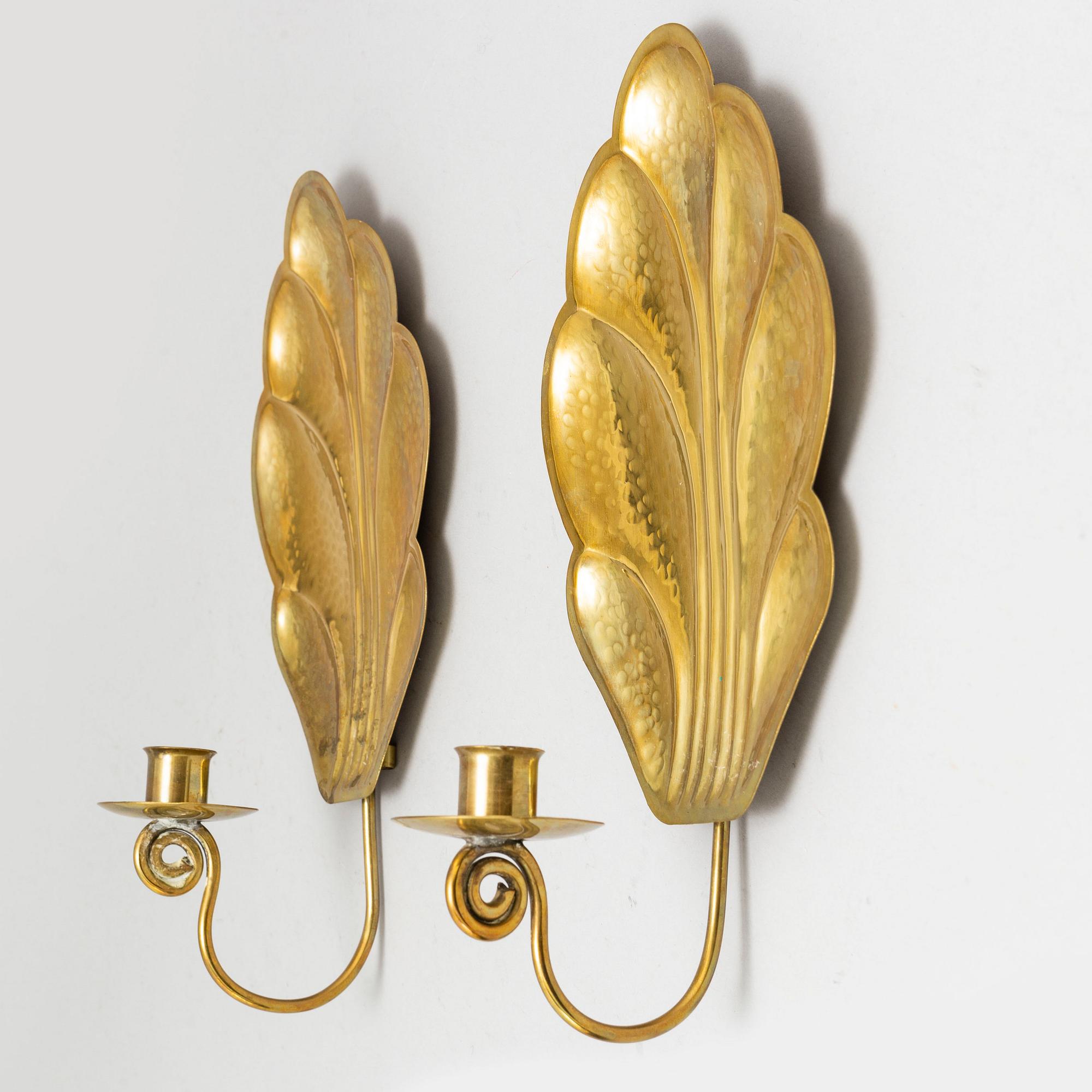 Four brass wall sconces  and one brass plate by Lars Homström, Arvika, second half of the 20th century.