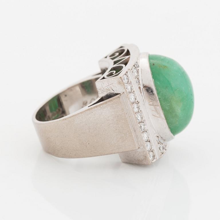 An 18K white gold ring set with a cabochon-cut emerald and round- and eight-cut diamonds.