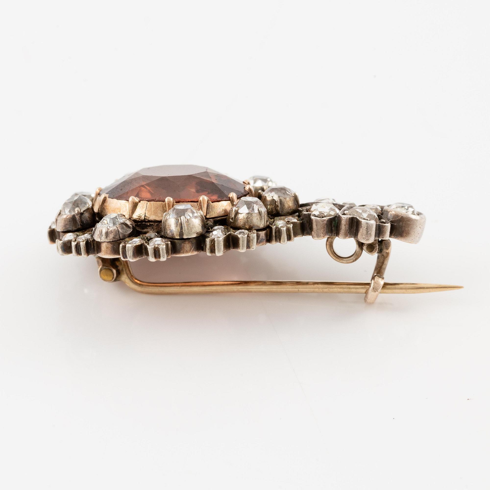 A brooch 14K gold and silver with a faceted zircon and old- and rose-cut diamonds.